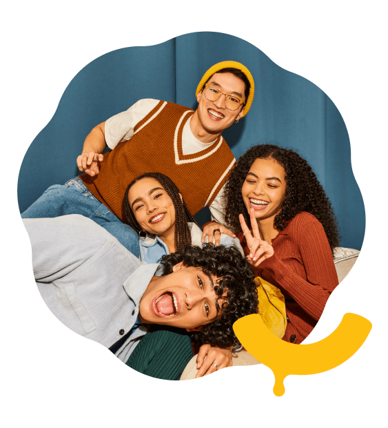 Four smiling young people in a group hug dog pile enjoying connecting with the Kraft Mac & Cheese community.